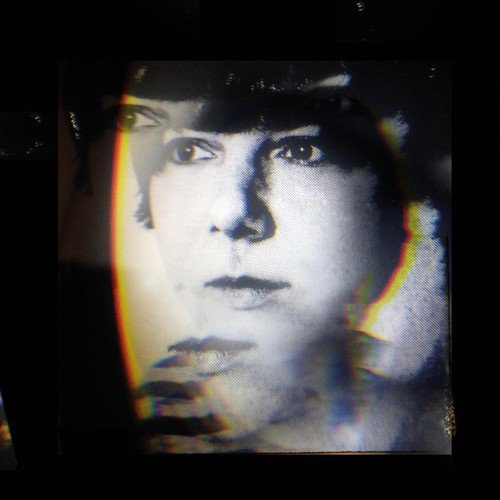 "CD cover with a black-and-white portrait and distorted, rainbow-colored edges."