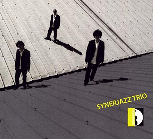 "Album cover with three men in suits standing on a metal roof."