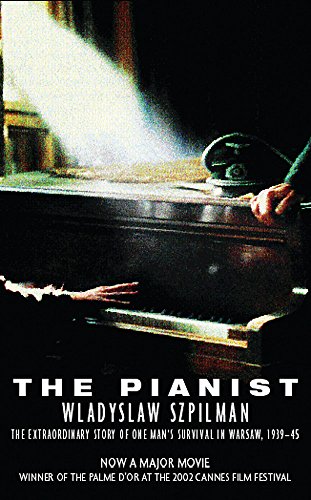 A hand plays a grand piano under a beam of light in a dark room.