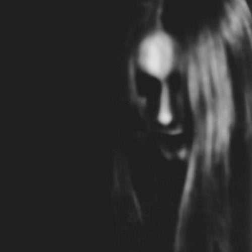 The image is a blurry, black-and-white photograph. The alt text is: "Blurry, black-and-white image of a person's face with long hair."