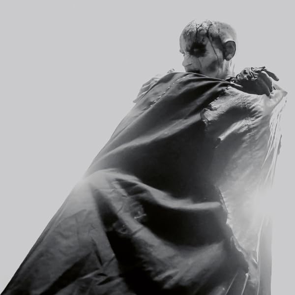 Black and white photo of a person with corpse paint and dark clothing.