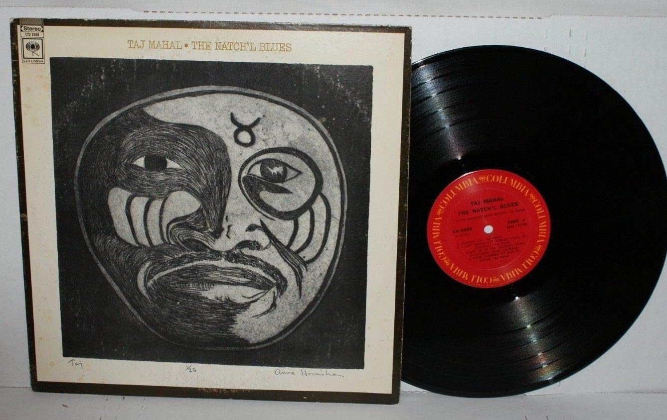 Taj Mahal album cover with abstract face and vinyl record beside it.