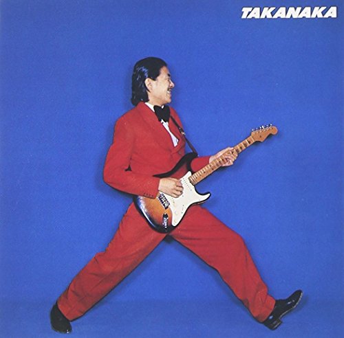 Masayoshi Takanaka in a red suit playing an electric guitar.
