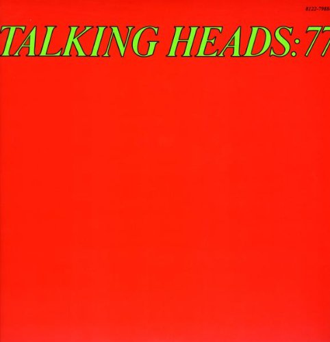 Red album cover with green text, partially concealing a black vinyl record.