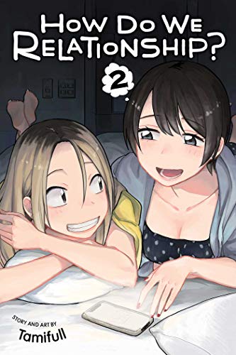 Two young women lying on a bed looking at a smartphone together.