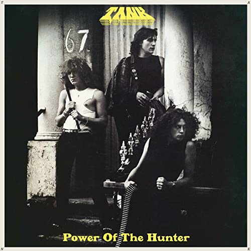 1980s album cover featuring three people in dark clothing.