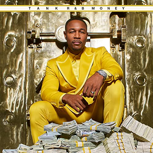 Tank in a yellow suit poses in front of a vault door and money.