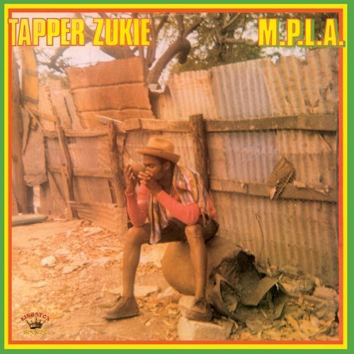 "Album cover with a man crouching, surrounded by corrugated metal and burlap sacks."