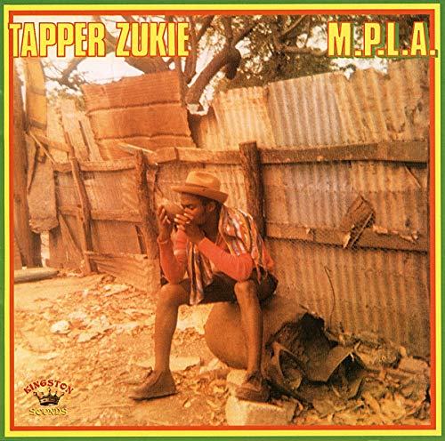 Vinyl record cover: man playing harmonica seated against a corrugated wall.