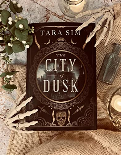 Book cover, "City of Dusk" by Tara Sim, with gothic and skeletal props.