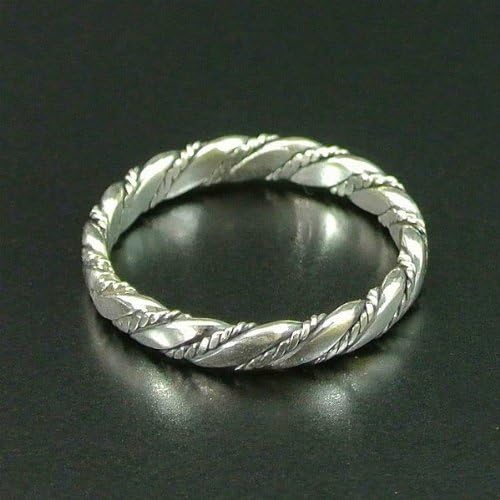Silver twisted band ring against a dark, reflective surface.