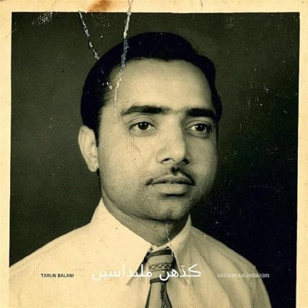Sepia-toned portrait of a man in a suit and tie, vinyl record cover.