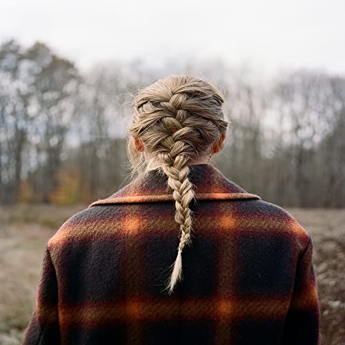 Woman with long braid wearing a plaid jacket, seen from behind.