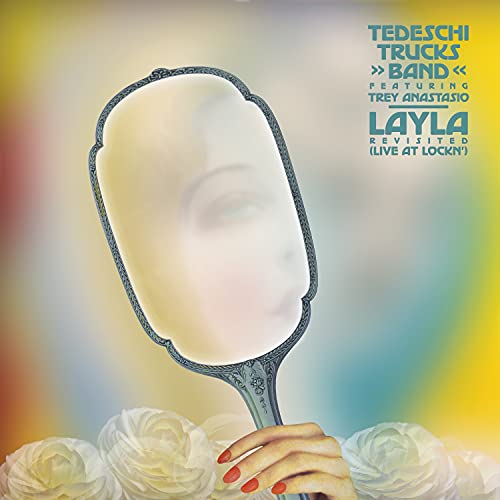Album cover featuring a hand holding a mirror with a face, and flowers.