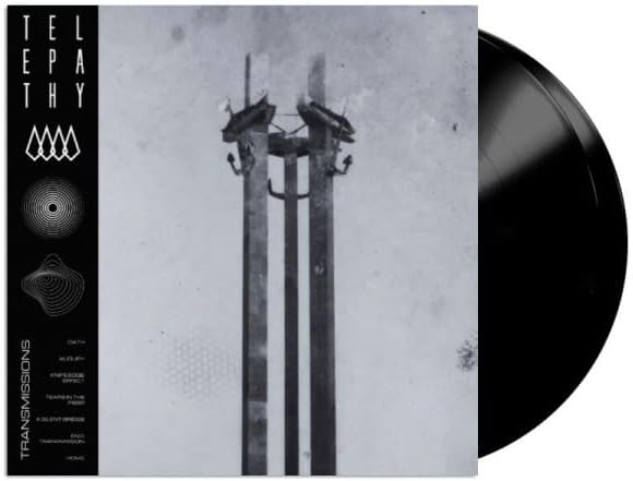 Vinyl record with album art depicting power lines against a cloudy sky.