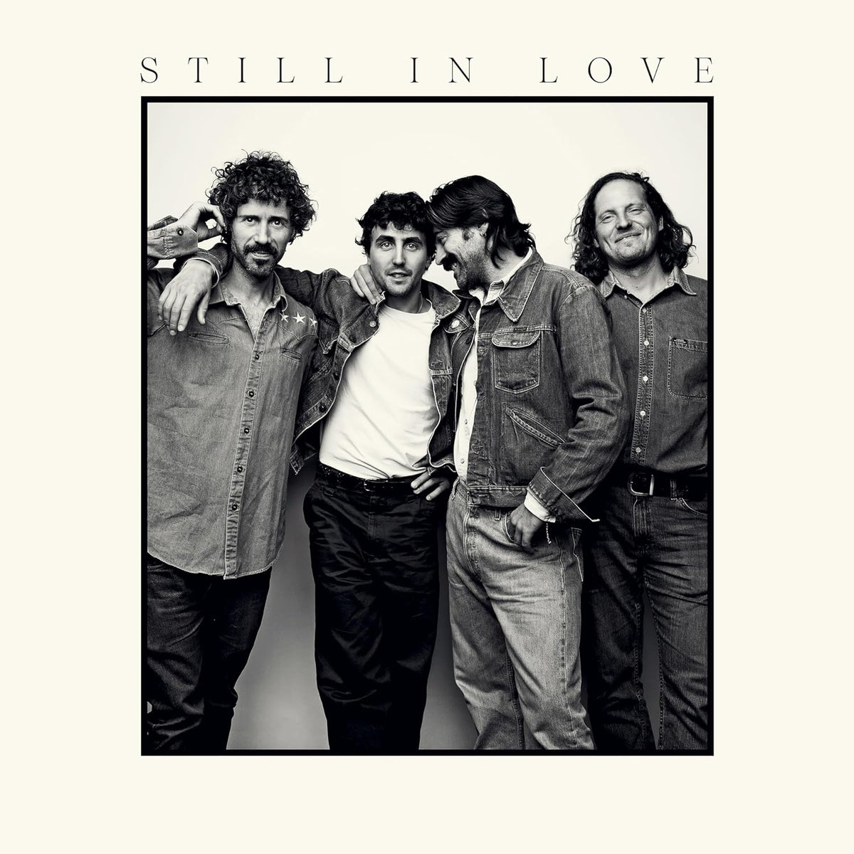 Black and white portrait of four men standing together, titled Still In Love.