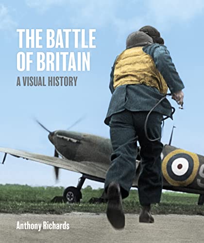 A pilot in a yellow life vest runs toward a parked Spitfire fighter plane.