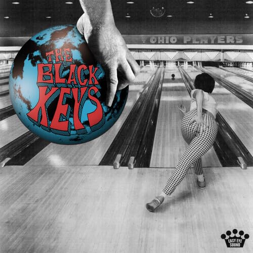 Bowling alley scene with a large bowling ball and a woman preparing to bowl.