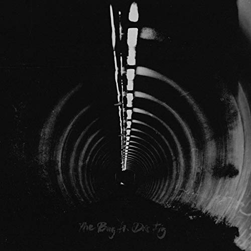High-contrast black and white photo of a tunnel with lights receding into distance.