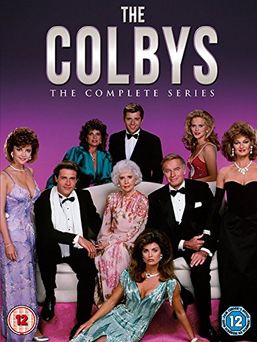 Cast of The Colbys posing for a formal portrait against a purple background.