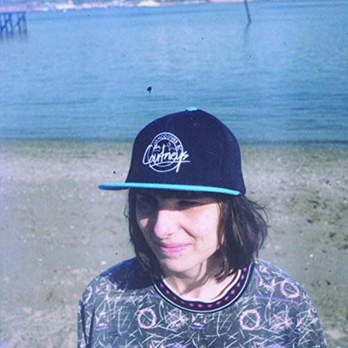 A woman wearing a black hat with a blue brim and a patterned shirt.
