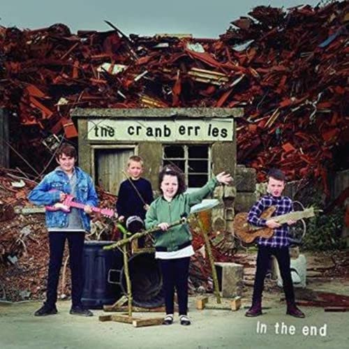 The Cranberries album cover, band standing amidst a scrap metal pile.