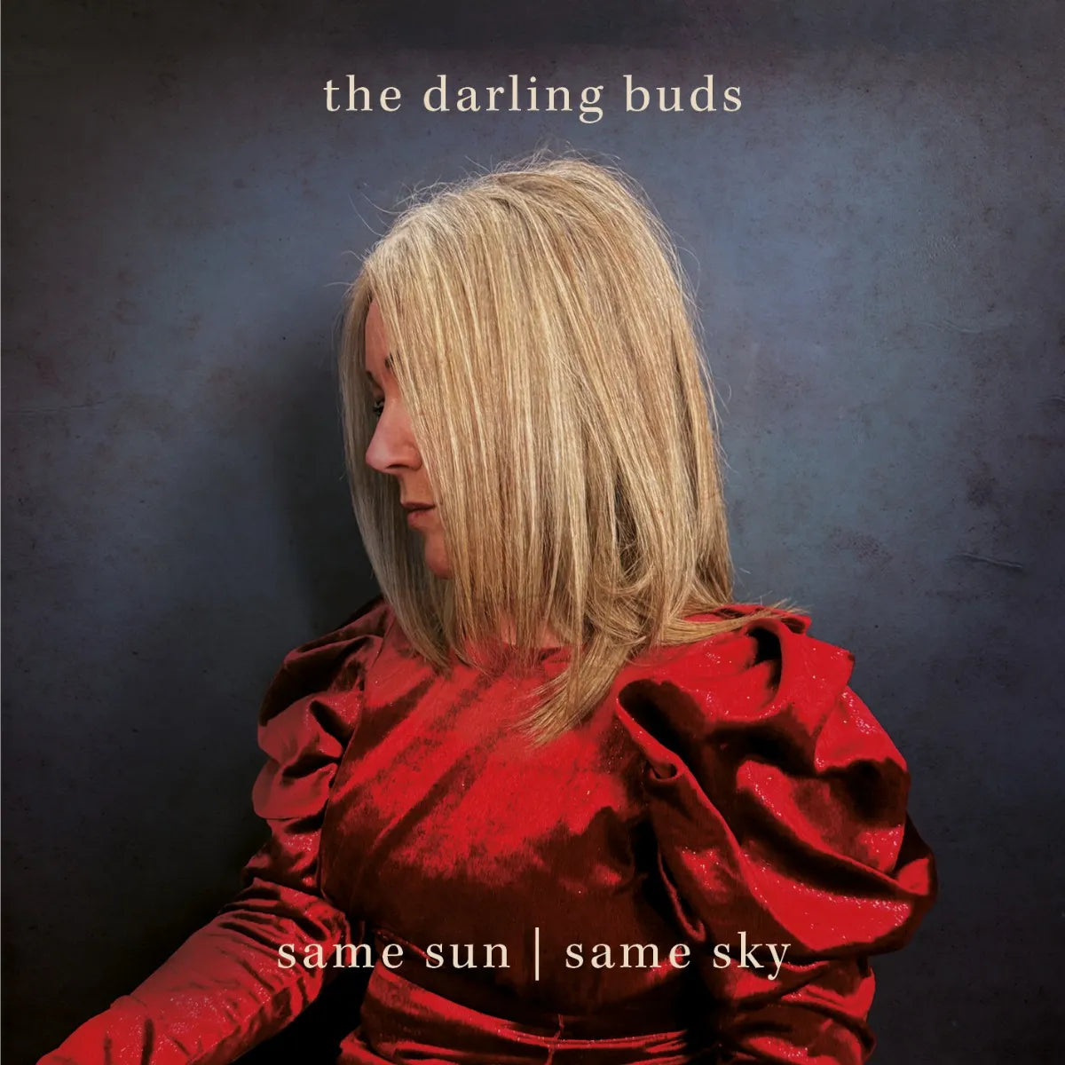 CD cover: woman in red dress, side profile, dark background.