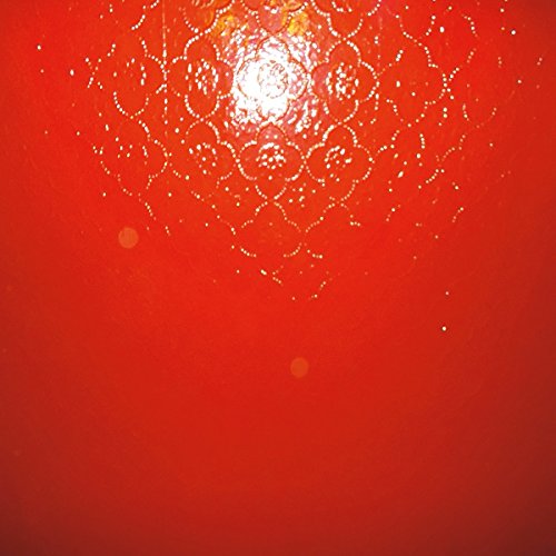 Red vinyl record with a circular, patterned, embossed design.