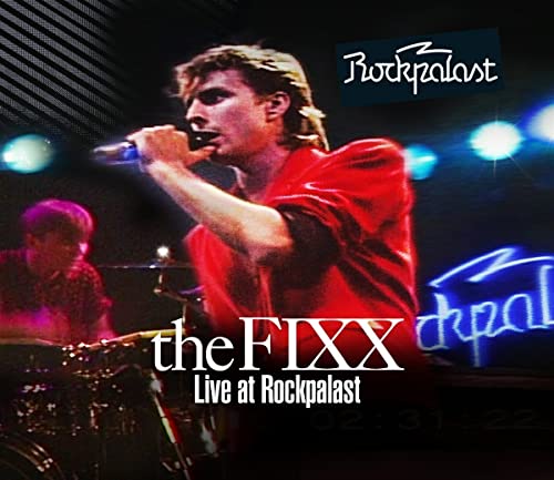 The Fixx live performance image with singer at a microphone.