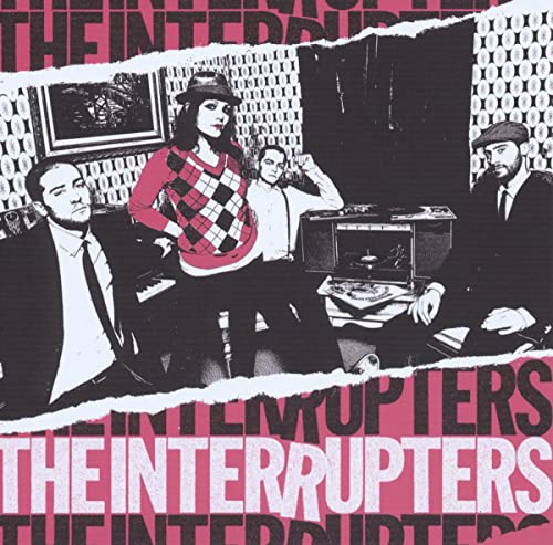 The Interrupters band members posing in a vintage room with pink and black graphics.