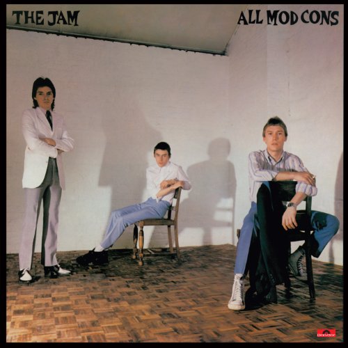 The three members of The Jam pose in a room with white walls.
