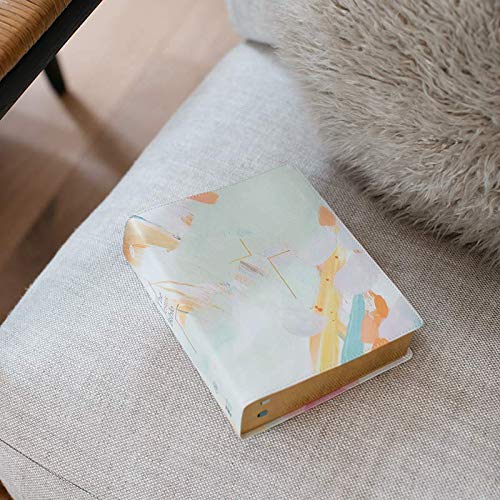 Teal and multi-colored Bible resting on a light gray textured surface.