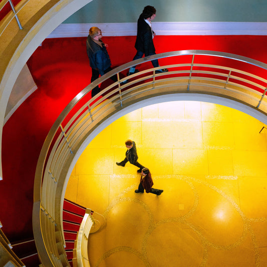 Overhead view of four people walking on a spiral staircase.