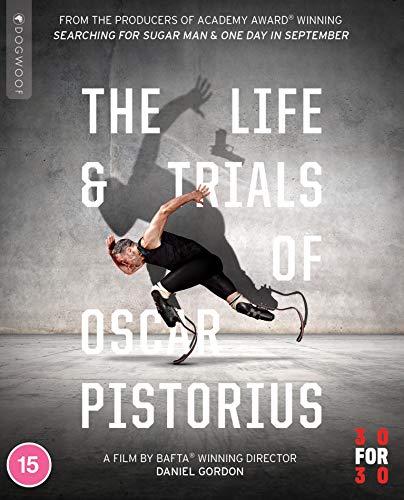 Man in prosthetic legs on concrete floor with shadow behind him on wall.