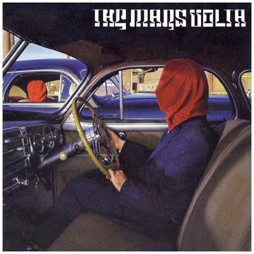 "Album cover featuring a person in a vintage car with a red cloth over their head."