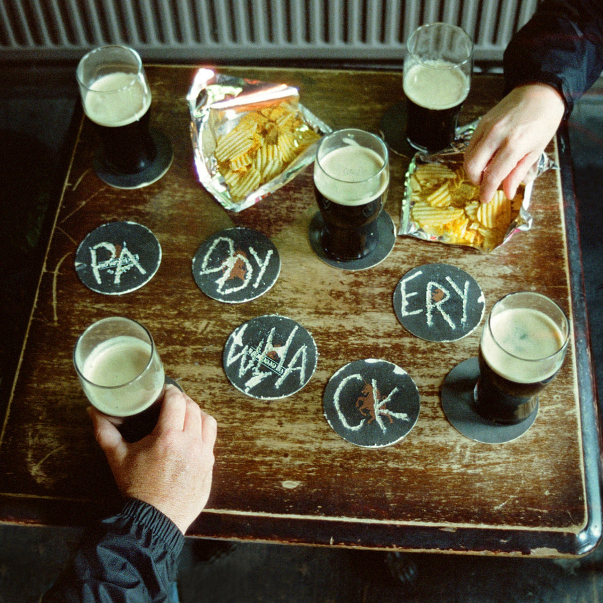 CD cover with pints, beer mats spelling “Paddywhackery”, and crisps.