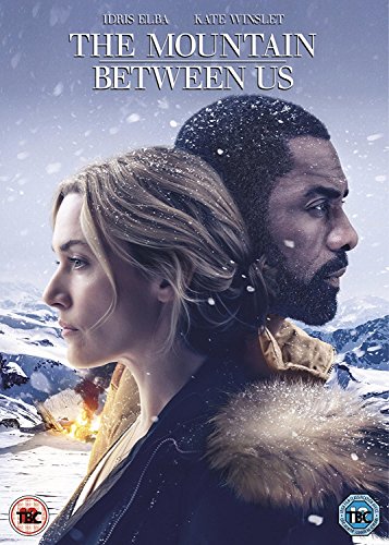 Idris Elba and Kate Winslet stand back-to-back in a snowy mountain landscape.