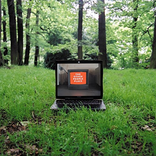 Laptop displaying a room with a television, set in a grassy field.