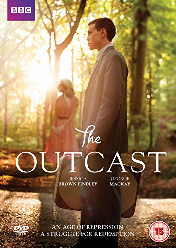 A man in a suit holding a suitcase stands in a sunlit forest.