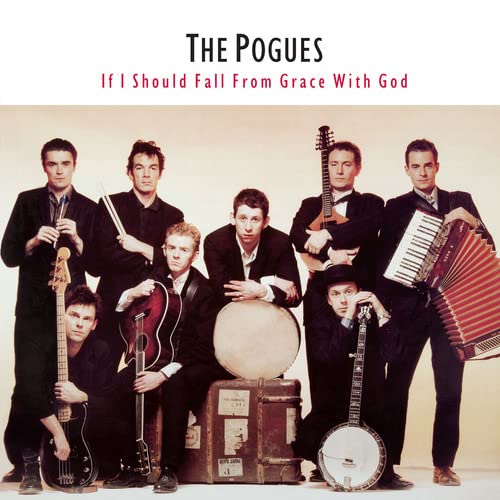 The Pogues band members pose with various musical instruments in front of a vintage suitcase.