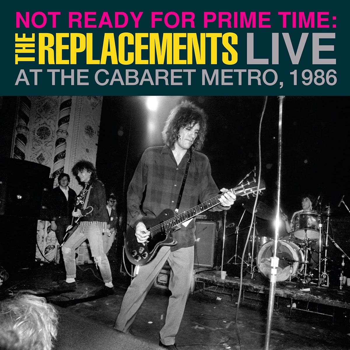 Black and white photo of The Replacements performing live onstage, 1986.