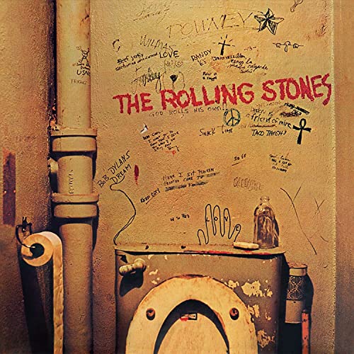 Graffiti-covered wall with a toilet and pipe, featuring The Rolling Stones band name.