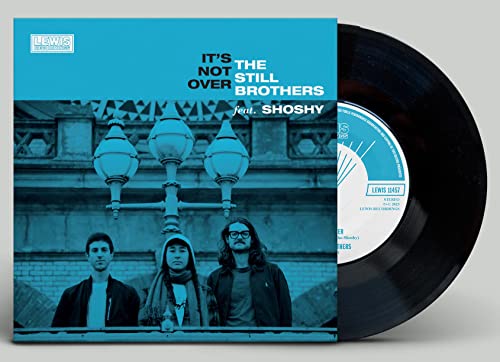 Vinyl record with album cover featuring three people and street lamps.