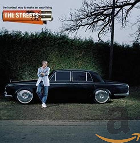 A man stands beside a black vintage car with a lighter graphic above.