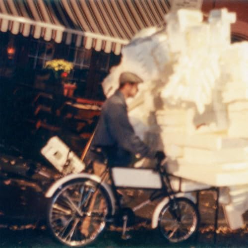 Vinyl record cover featuring a blurry image of a man and bicycle.