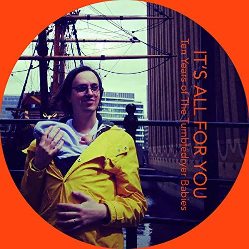 CD cover: man in yellow jacket holding a baby, ship in background.