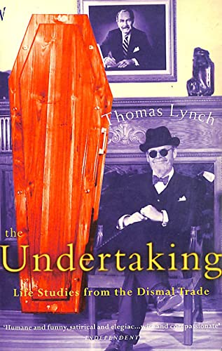 Book cover: red coffin, man in suit and sunglasses, portrait backdrop.