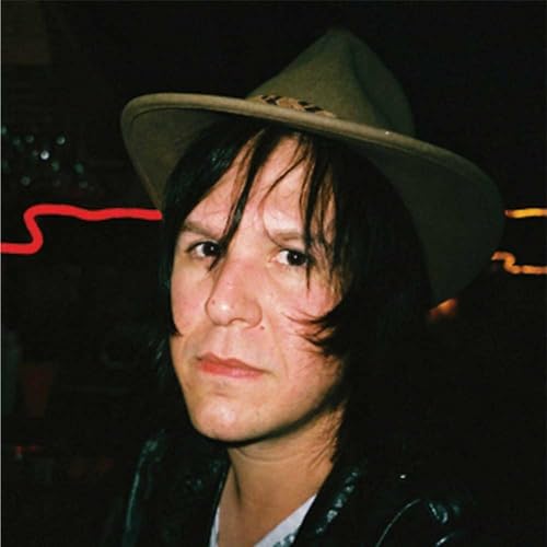 Close-up portrait of a person wearing a light-colored hat, dark hair.