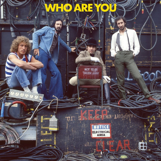 The Who band members posing amongst electrical equipment and cables.
