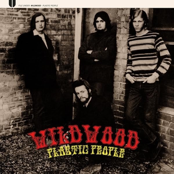 Black and white album cover featuring four men standing against a brick wall.